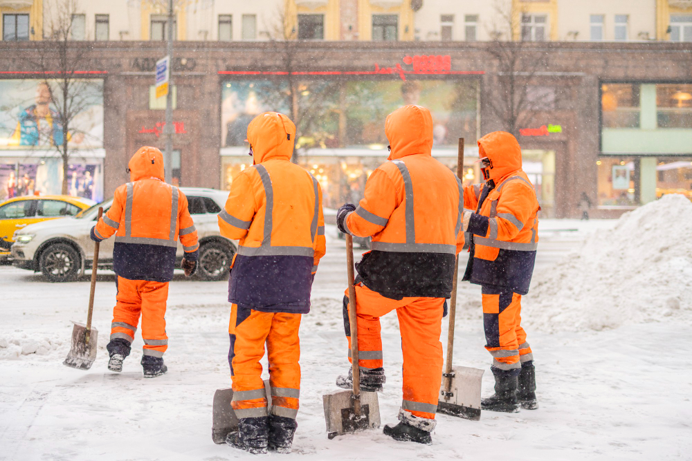 A group of city workers cleaning snow in Ontario, Canada with winter safety equipment